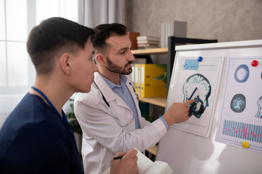 Two young neurologists looking concentrated while discussing the medical case