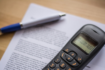 To make a phone call. Ink pen on a contract