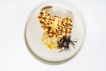 grilled cauliflower with seaweed on the white plate
