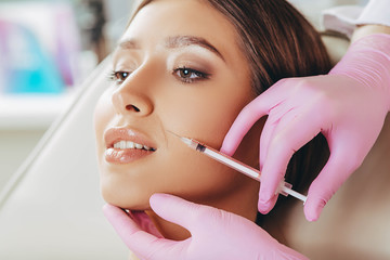 woman with mimic wrinkles near mouth getting beauty injections. Botulinum toxin injection for...