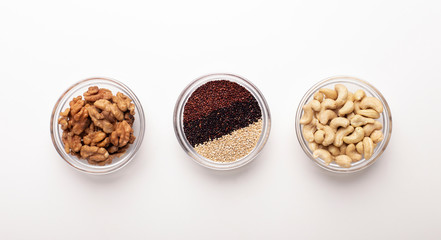 Bowls with quinoa, walnuts and peanuts on white