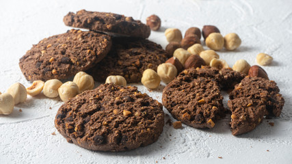 Chocolate cookies for breakfast with mint and hazelnut and a glass of milk on a gray table