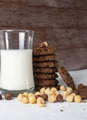 Chocolate cookies for breakfast with mint and hazelnut and a glass of milk on a gray table