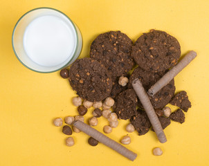 Chocolate cookies for breakfast with mint and hazelnut and a glass of milk on a gray table
