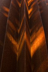 Abstrakte Detailaufnahmen einer verrosteten Stahlkonstruktion mit selektivem Fokus bei Seitenlicht, abwechselnd helle Bereichen und Schattenbereiche