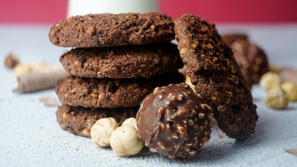 Chocolate cookies for breakfast with mint and hazelnut and a glass of milk on a gray table