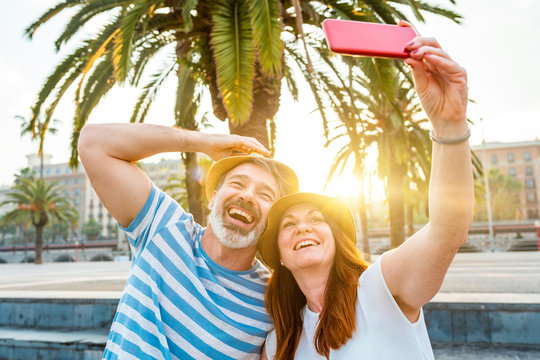 Adult couple dating and taking a selfie in Barcelona at sunset