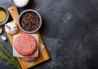 Raw minced home made grill beef burgers with spices and herbs. Top view with space for your text © DenisMArt