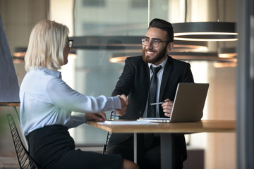 Middle eastern ethnicity HR manager hiring elderly woman people handshaking