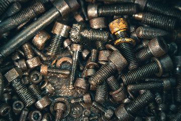 Pile of rustic nuts and bolts in grease.