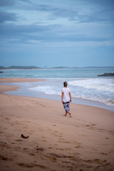 Tangalle, Sri Lanka : 2020 NOV 25 : Young Blonde woman walk the beach in Sunset in the beach of Tangalle, Sri Lanka.