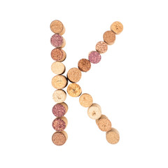 The letter "K" is made of wine corks. Isolated on white background