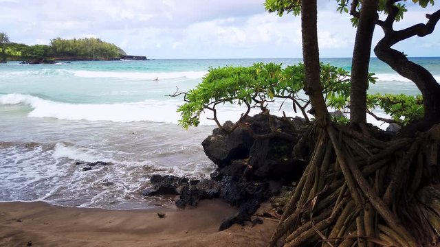 Koki Beach Park Maui. The dark red sand at Koki Beach was produced by the nearby cinder cone hill of Ka Iwi O Pele. Koki Beach is one of two famous Hana surf breaks and favorite spot for local surfers