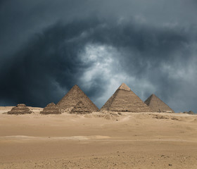 Obraz na płótnie Canvas The Giza pyramid complex under dramatic grey stormy sky