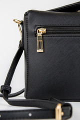 Detalle de bolso negro con cremallera dorada