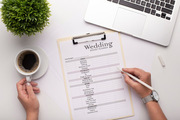 Woman planning her wedding, calculating budget on white