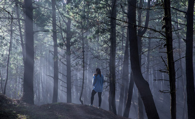 A woman in a foggy forest