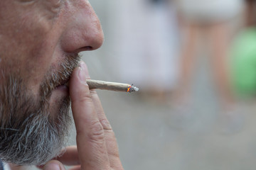 Bearded a man smoking a cigarette. Close-up.