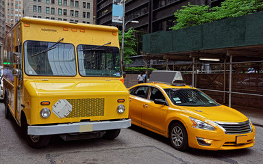 Traditional yellow taxi and a van in Manhattan street