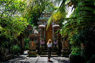 young woman standing in front of a temple in bali