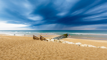 Blick auf den Strand in Lacanau Océan, Frankreich, bei aufziehenden, dunklen Gewitterwolken