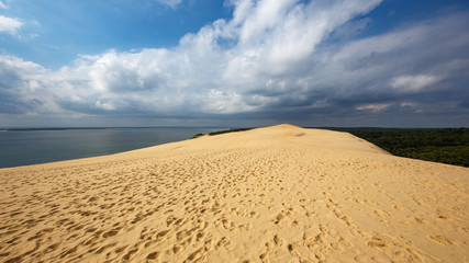 Imposanter Ausblick von einer Sanddüne in Frankreich in im Sommer, mit bedrohlichen Wolken.