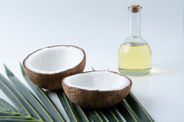 coconuts and Coconut oil product organic for cosmetic natural care health in a bottle put on a white table,  Concept: alternative aromatherapy aromatic ingredient vitamin for therapy and massage spa
