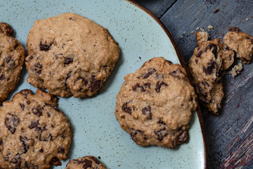 Chocolate cookies, on rustic wood next to cocoa in different forms