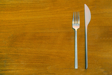 Top View of fork and Knife on wooden background. Fork and Knife on wooden background. Cutlery on wooden table. Text Space.