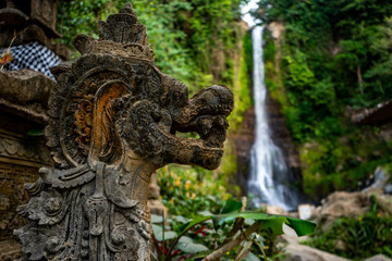 Fototapeta na wymiar stone dragon sculpture and waterfall in background