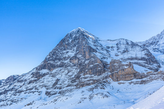 Stunning close up view of Eiger north face from Kleine Scheidegg on a winter sunny day, famous mountain of Swiss Alps on Bernese Oberland near Jungfrau, Interlaken, Switzerland