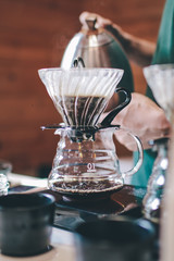 Hand drip coffee, Barista making drip coffee.Barista pouring water over the coffee powder the hot water drips through the filter and grind beans above into glass mugs