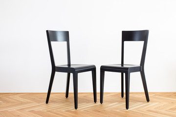 modern simplistic black chairs on a wooden flor in front of white background