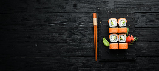 Traditional sushi - Philadelphia with salmon, avocado and cheese. Japanese cuisine. Top view. © Yaruniv-Studio