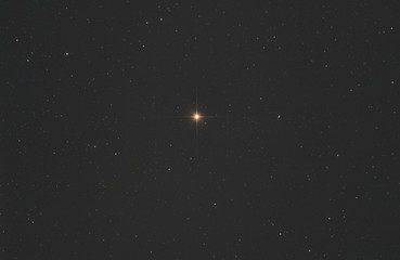 Closeup of Betelgeuse star or alpha Orionis in Orion constellation, with many stars as background...