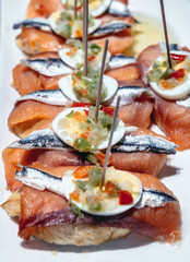 Pinchos with salmon fish - variety of traditional Spanish snacks in San Sebastian city also called Donostia in Gipuzkoa region of Spain
