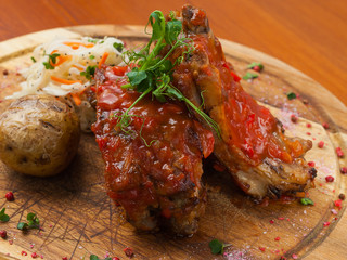bbq pork ribs with potatoes and kou slow salad on a wooden Board