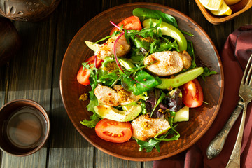 Grilled chicken breast with green and red pepper, avocado, tomatoes, lettuce, cucumber and fresh herbs. Flat lay image