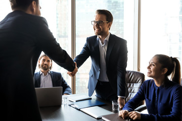 Happy successful businessman in suit shaking hand of applicant.