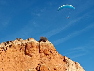 Man is paragliding in Albufeira in Portugal at the beach