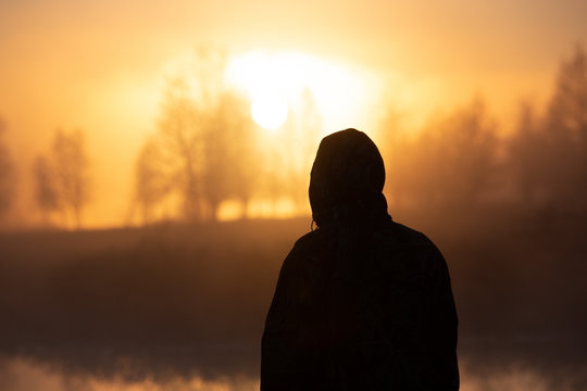 silhouette of man in foggy sunrise