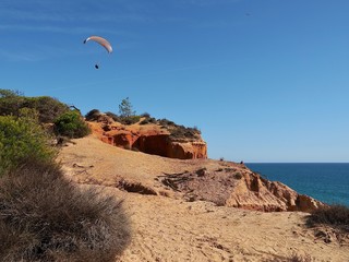 Man is paragliding in Albufeira in Portugal at the beach