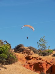 Man is paragliding in Albufeira in Portugal at the beach