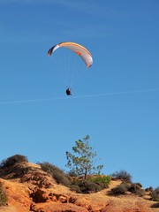 Man is paragliding in Albufeira in Portugal at the beach