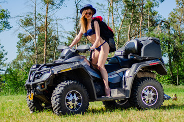 Sexy, slim, pretty, attractive girl in swimsuit on the ATV quad bike. ATV concept.