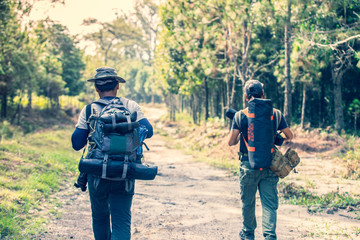 Fototapeta premium Group friend walking in the wild with a heavy backpack. Travel Lifestyle wanderlust adventure concept summer vacations in the wild