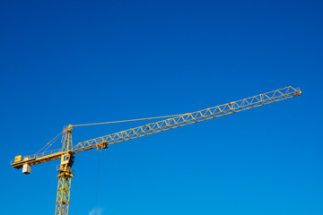 Construction crane on blue sky background with copy space