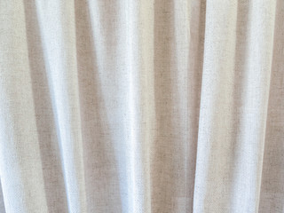 Beige curtains made of natural linen with many folds