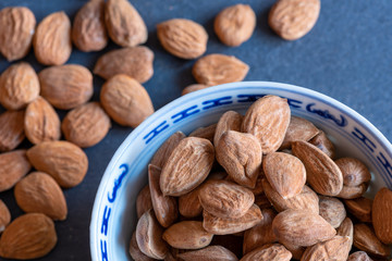shelled almonds in a cup and on a slate board