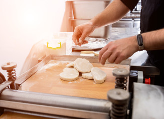 Chef preparing dough for pastry, dumplings, italian pasta or japanese wontons.